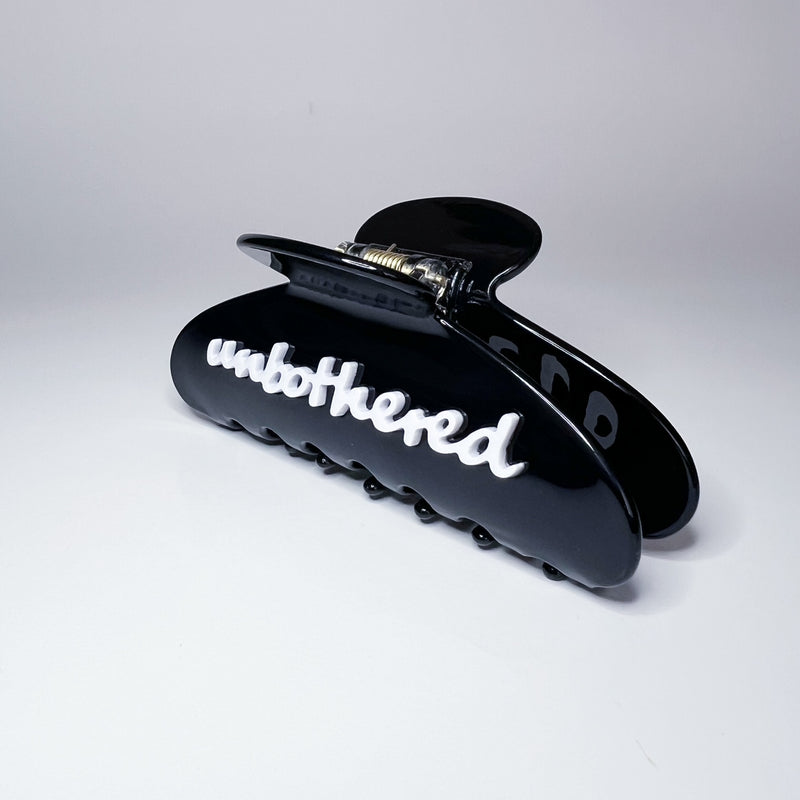 Two hair clips with 'unbothered' text on a white background